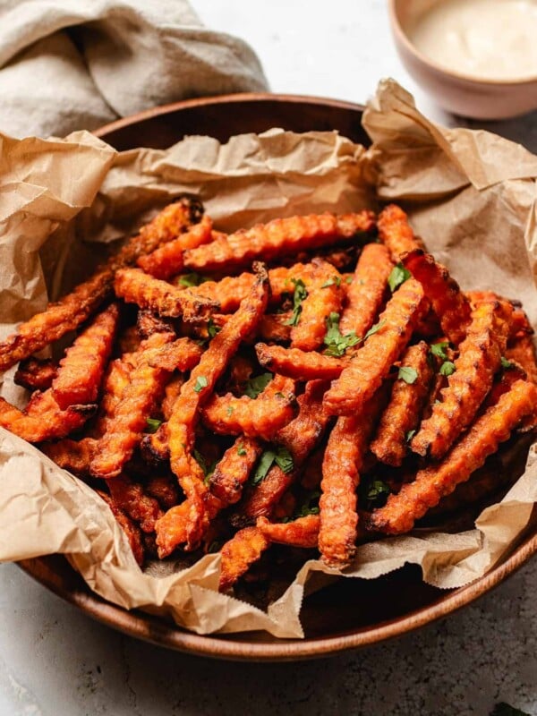 A side shot feature image shows a plate of crispy sweet potato fries air fried from frozen with dipping sauce on the side.