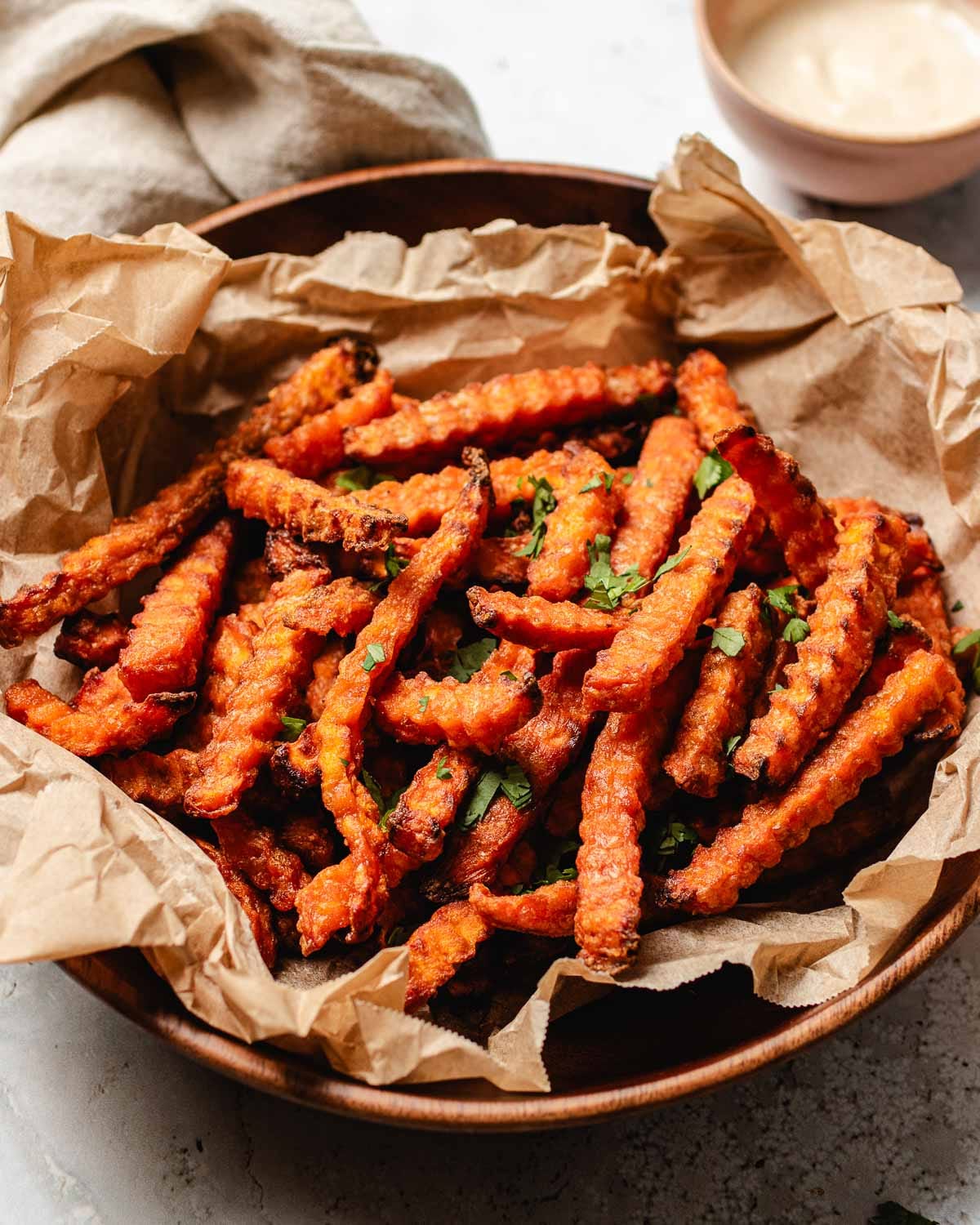 A side shot feature image shows a plate of crispy sweet potato fries air fried from frozen with dipping sauce on the side.