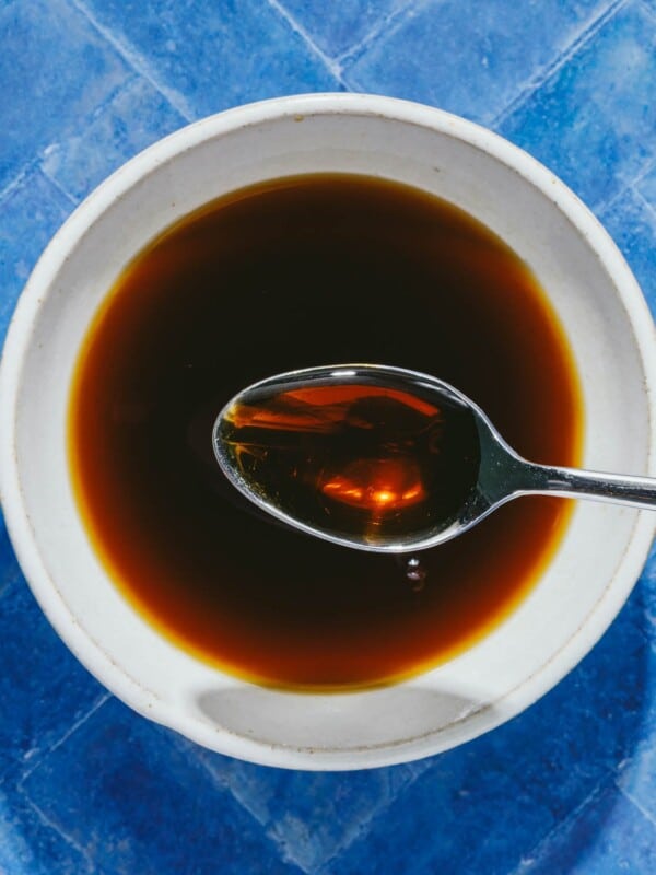 Feature overhead image shows a white sauce bowl with gluten free teriyaki sauce inside with a spoon.