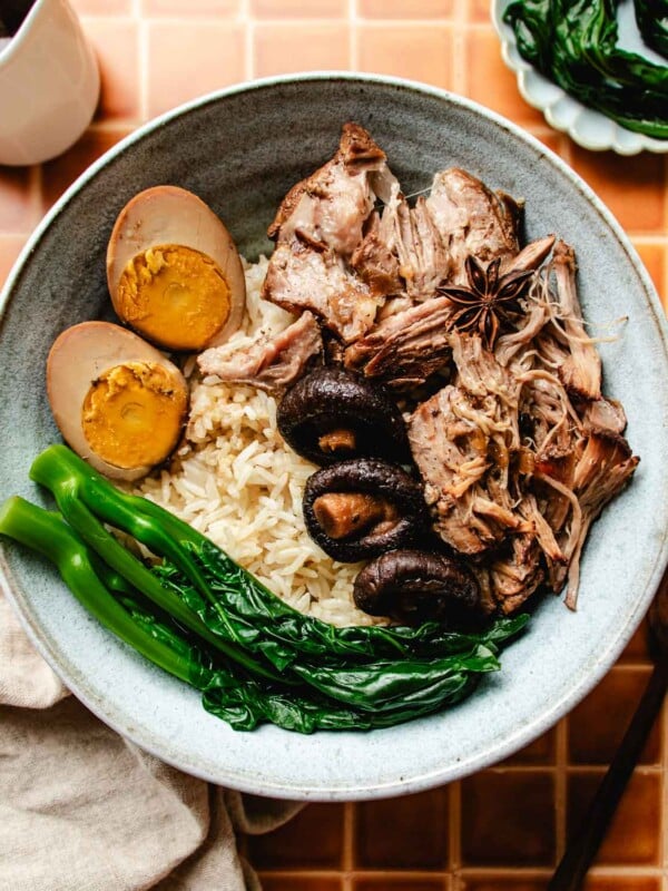 Feature image shows Taiwanese lu rou fan served in a light blue color bowl with rice, lu dan, and blanched vegetable on the side.