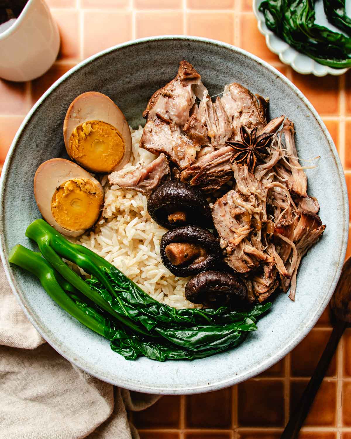 Feature image shows Taiwanese lu rou fan served in a light blue color bowl with rice, lu dan, and blanched vegetable on the side.