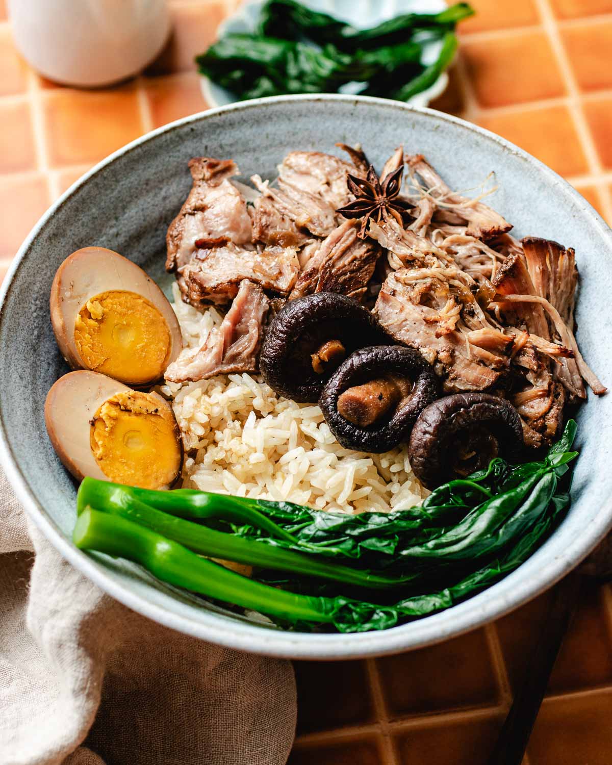 A side close shot shows how to serve lu rou fan with rice and lu dan in the bowl.