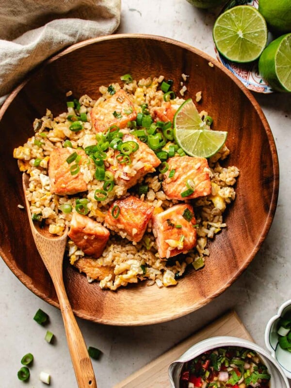 Feature image shows Salmon fried rice served with Thai chili sauce over a wooden plate.