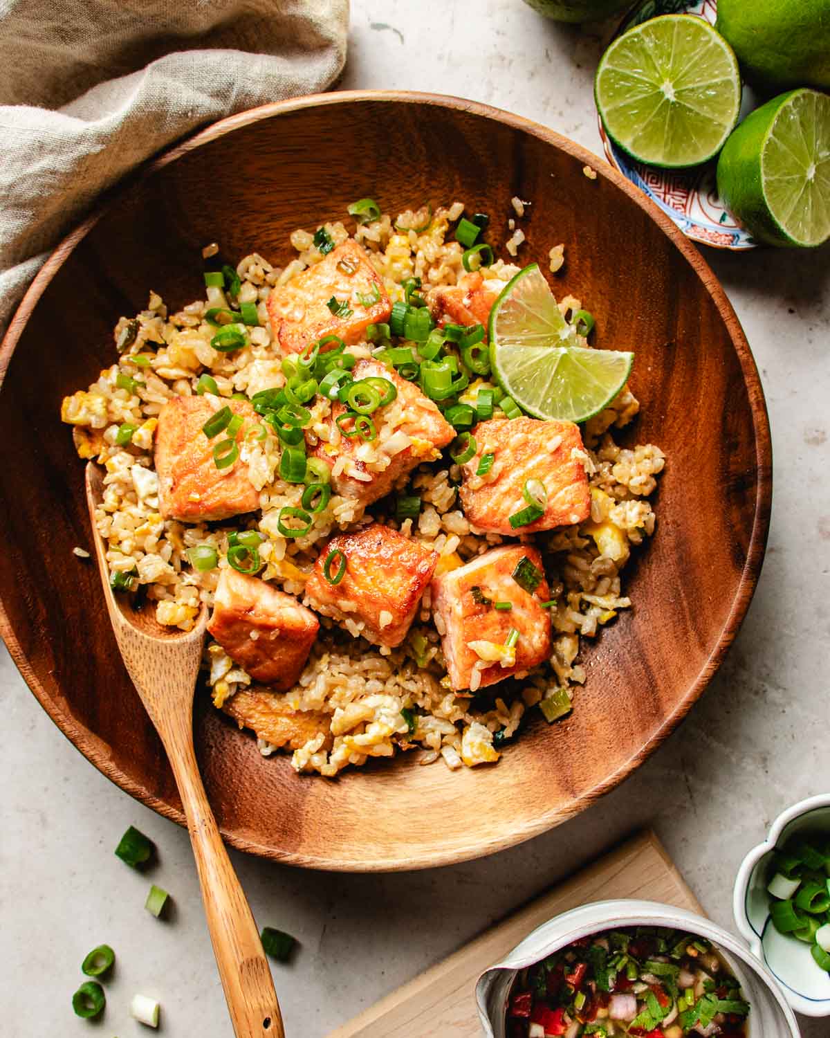 Feature image shows Salmon fried rice served with Thai chili sauce over a wooden plate.