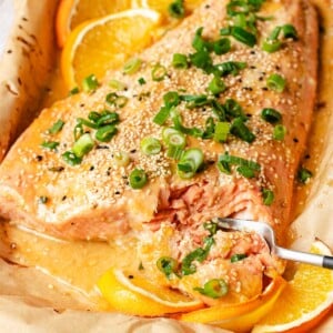 Recipe image shows orange glazed salmon oven baked to buttery tender with orange glaze and orange slices..