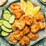 Recipe image shows air fried chicken karaage served over a big green color plate with lemon and cucumber slices on the side.