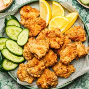 Recipe image shows air fried chicken karaage served over a big green color plate with lemon and cucumber slices on the side.