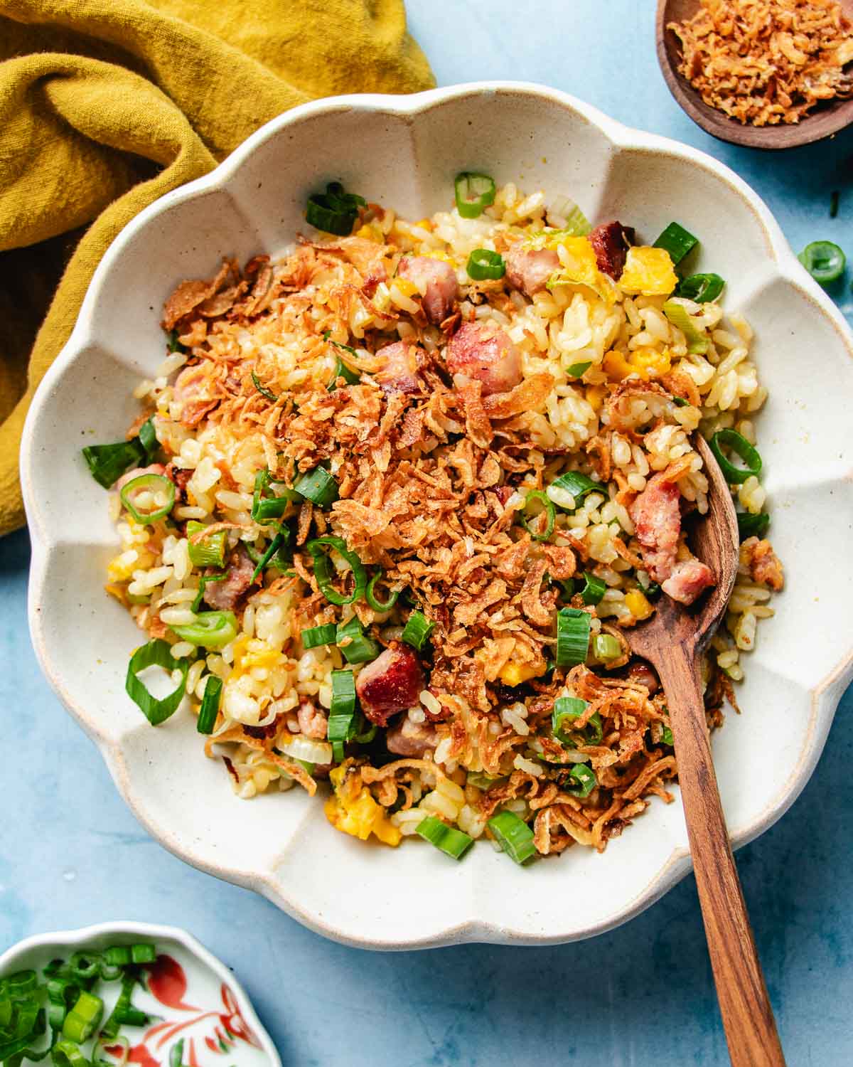 Feature image shows a plate of crisp and yellow golden fried rice, topped with crispy shallots, scallions, served over a white color plate.