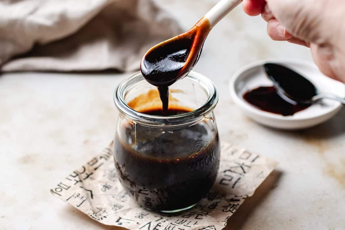 Image shows thick soy paste homemade in a glass jar with glossy consistency,