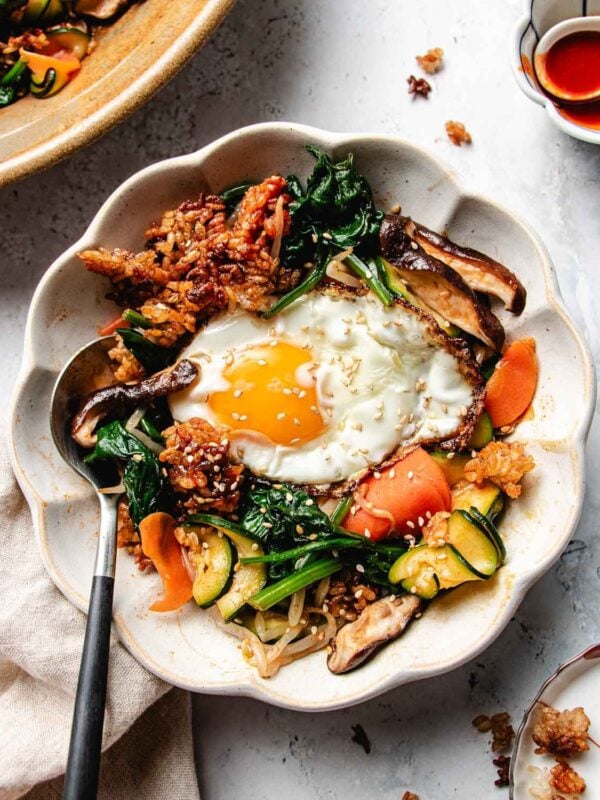 Feature image shows a bowl of vegetable bibimbap with crispy rice topping in one bowl.