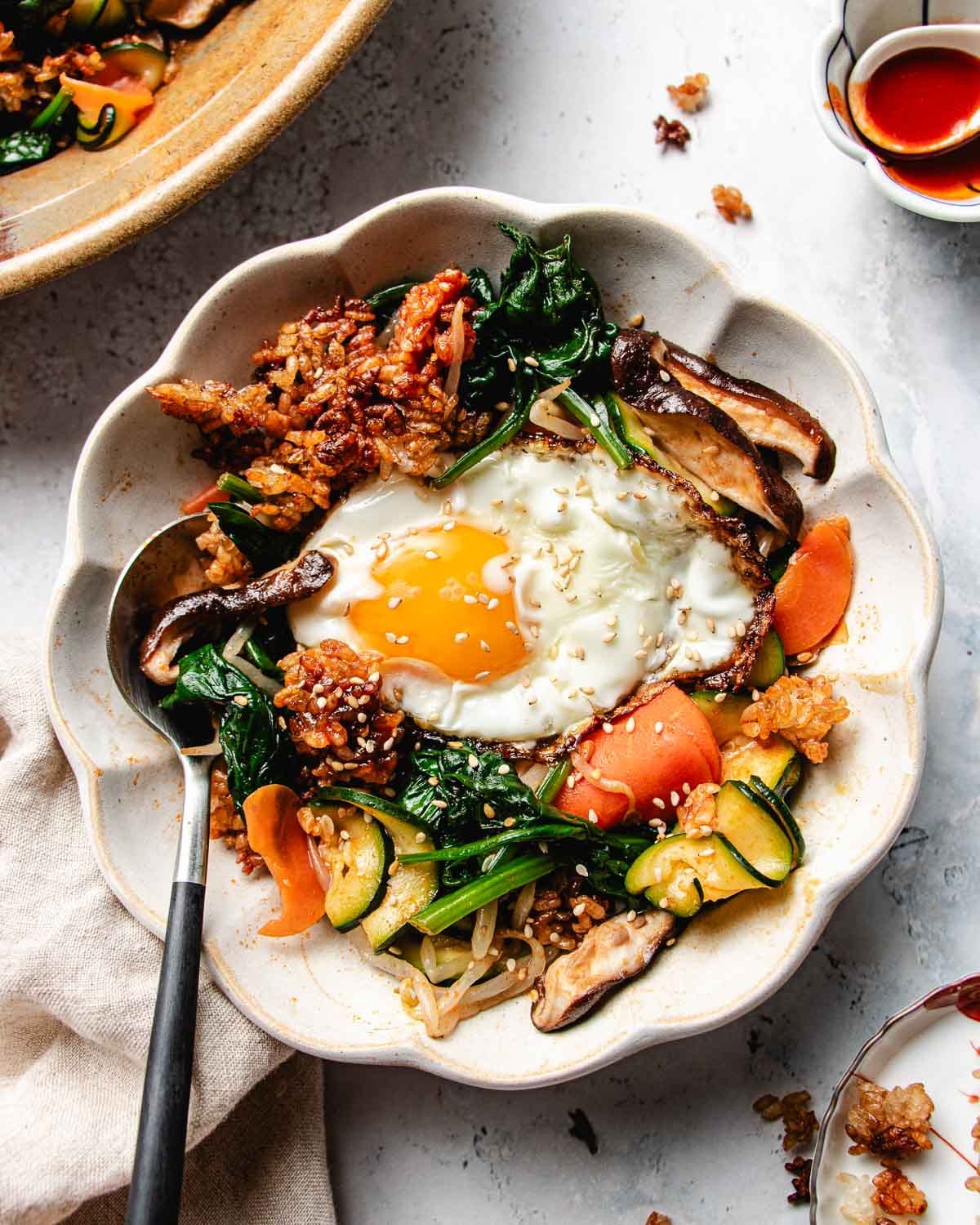 Feature image shows a bowl of vegetable bibimbap with crispy rice topping in one bowl.