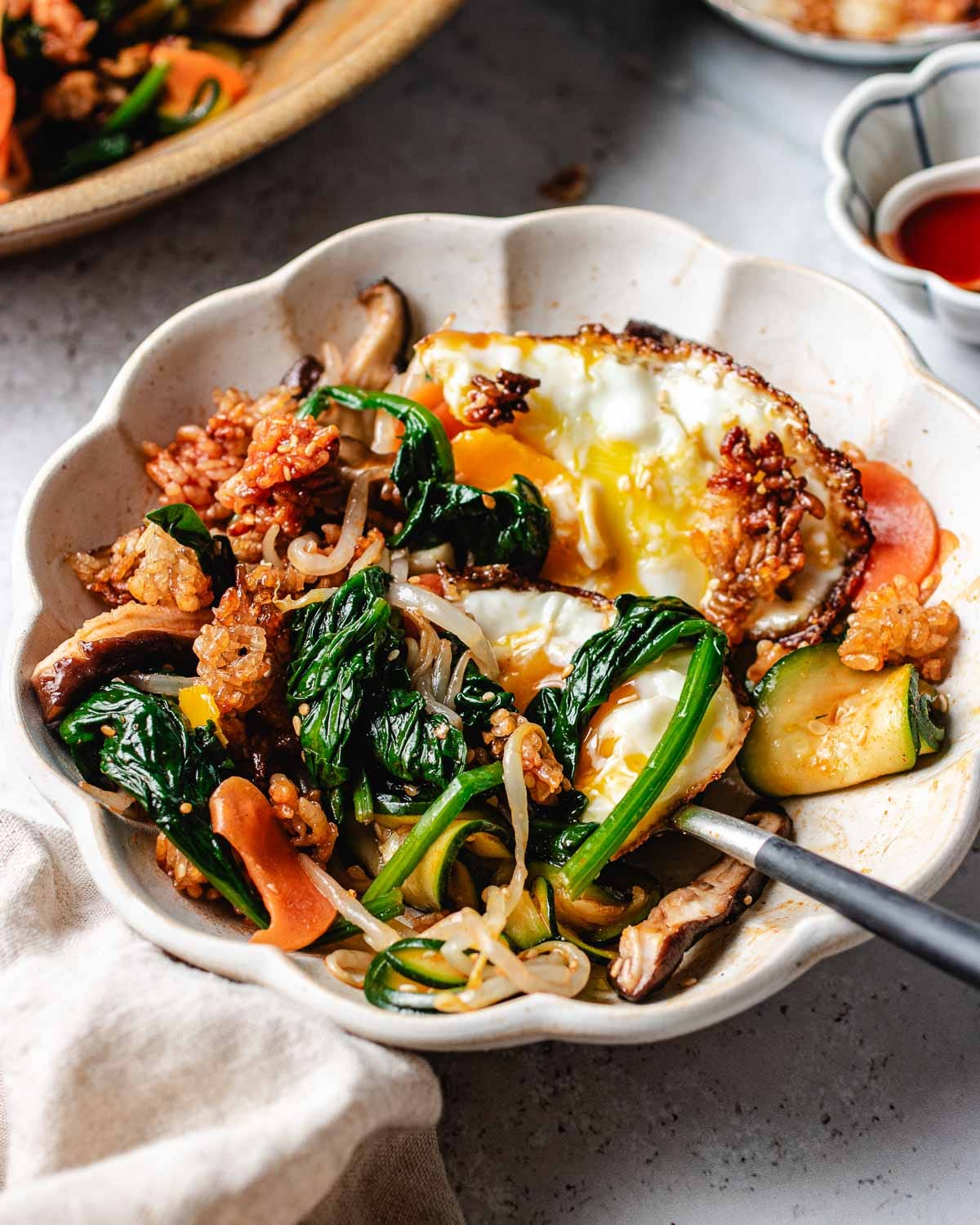 A side close shot shows crispy rice salad with bibimbap vegetables.
