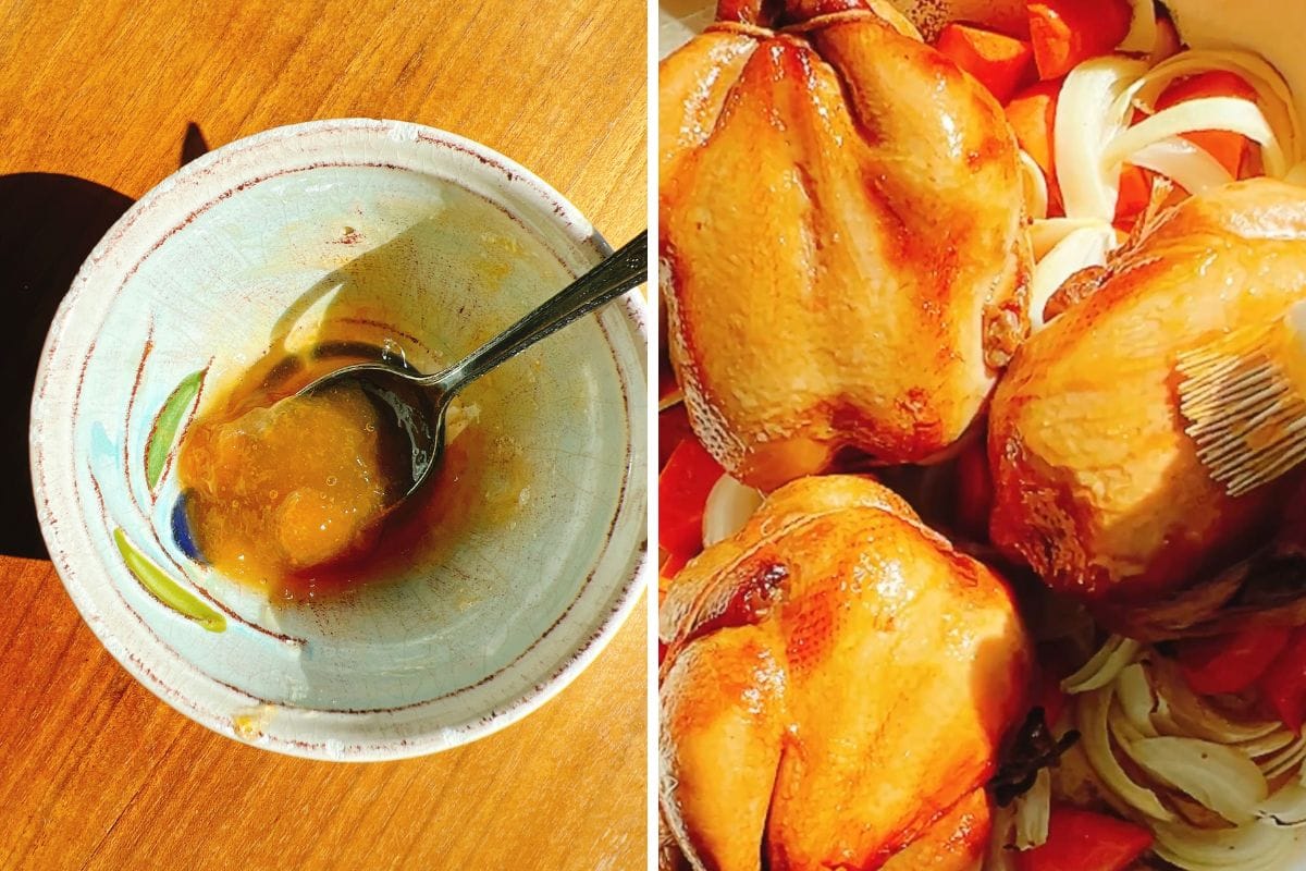 A bowl with a spoon holding a apricot sweet jam glaze sits on a wooden surface; next to it are roasted Cornish hens with golden skin, surrounded by carrots and onions. This dish highlights perfectly roasted Cornish hens for an elegant meal.