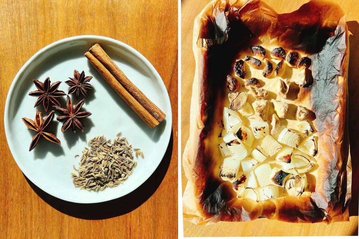 A white plate with star anise, cumin seeds, and a cinnamon stick—perfect aromatics for turkey pho bone broth—beside a tray of roasted, browned onion chunks on parchment paper, both set on a wooden surface.