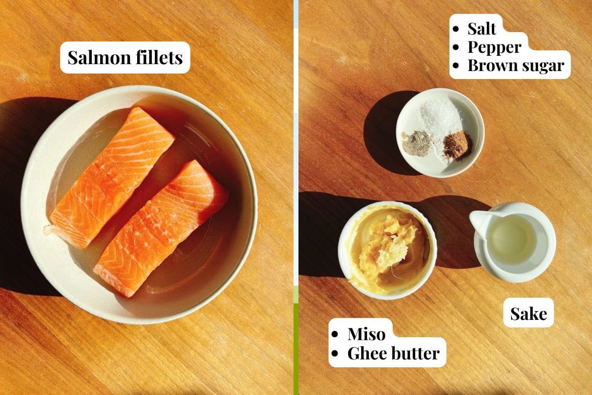 Two salmon fillets in a bowl on the left; on the right, bowls with salt, pepper, brown sugar, miso, ghee butter, and sake—each labeled—are neatly arranged on a wooden surface for a delicious miso butter salmon recipe.